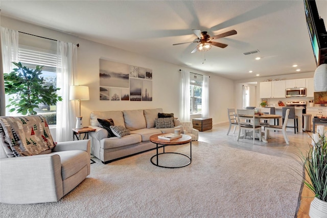 tiled living room with ceiling fan