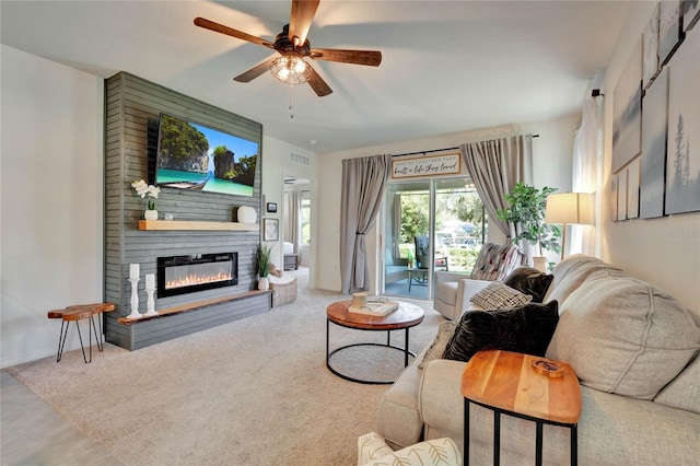 carpeted living room featuring ceiling fan and a fireplace