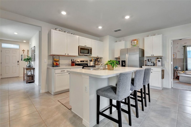 kitchen featuring white cabinetry, a center island with sink, and appliances with stainless steel finishes