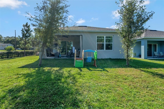 back of property featuring a yard, a patio, and ceiling fan