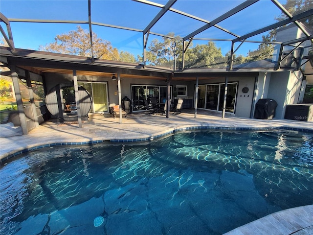 view of swimming pool featuring ceiling fan, area for grilling, a patio area, and glass enclosure