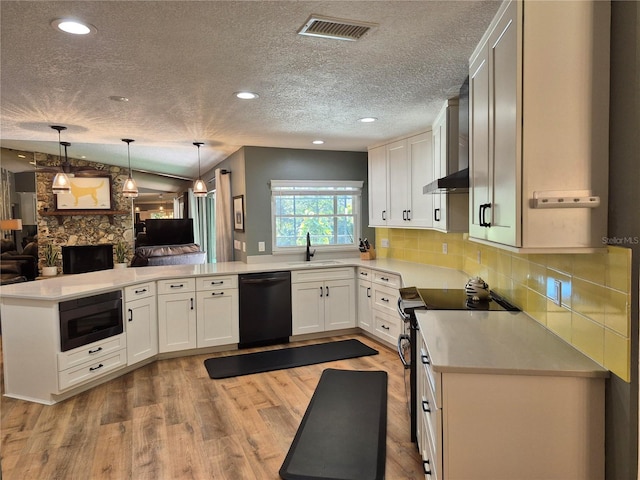 kitchen with sink, white cabinetry, light wood-type flooring, pendant lighting, and black appliances