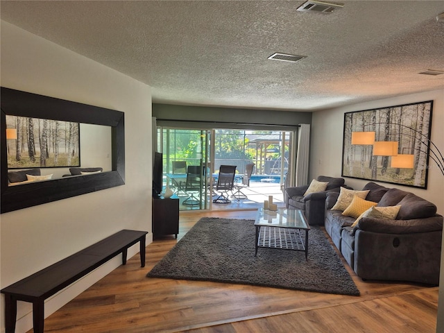 living room with wood-type flooring and a textured ceiling