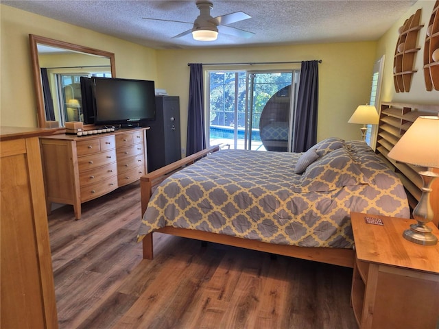 bedroom with dark hardwood / wood-style floors, access to outside, a textured ceiling, and ceiling fan