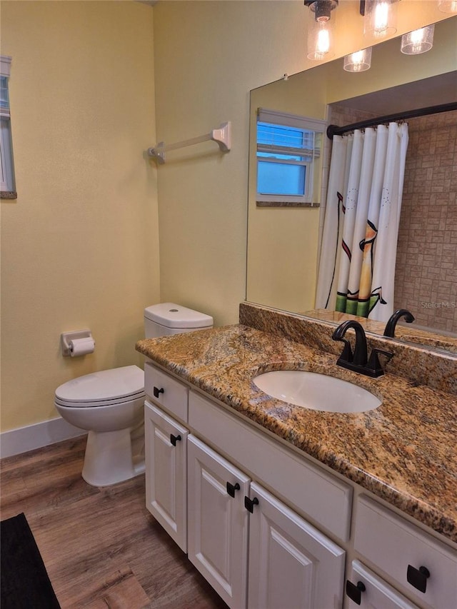 bathroom featuring hardwood / wood-style flooring, vanity, toilet, and a shower with curtain