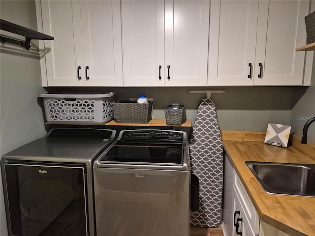 laundry room featuring cabinets, washer and clothes dryer, and sink