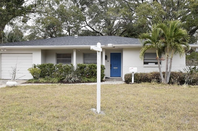 ranch-style house with a garage and a front lawn