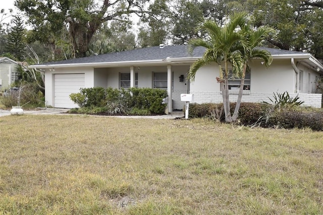 ranch-style house featuring a garage and a front lawn