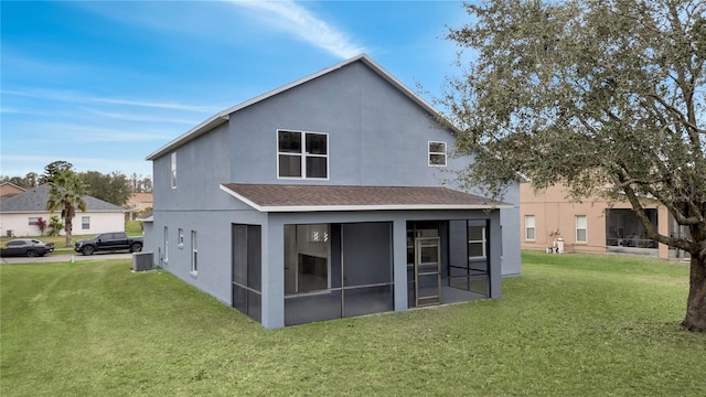 back of property with a yard, a sunroom, and central AC