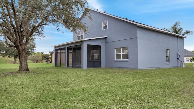 back of house featuring a lawn and a sunroom