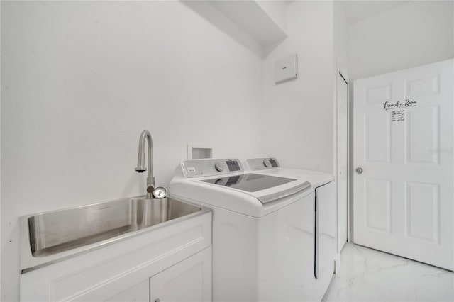 washroom featuring sink, independent washer and dryer, and cabinets