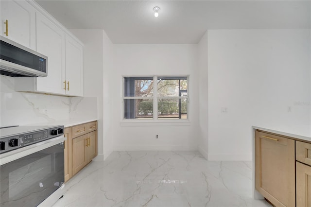 kitchen featuring white cabinets, stove, backsplash, and light brown cabinets