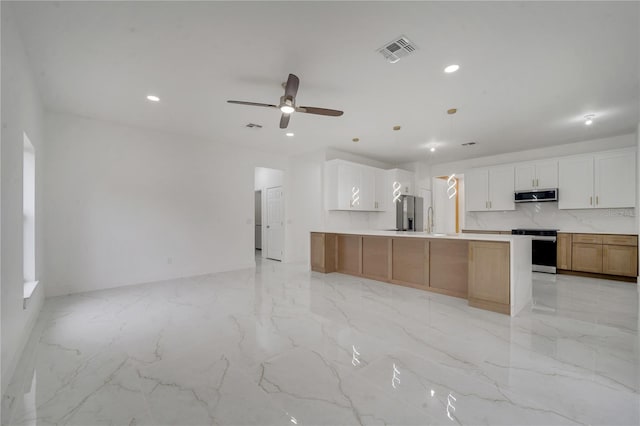 kitchen with a spacious island, appliances with stainless steel finishes, white cabinetry, and pendant lighting