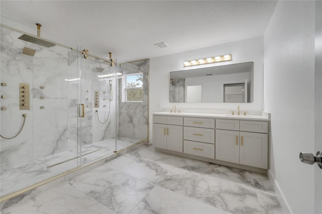 bathroom with an enclosed shower, vanity, and a textured ceiling