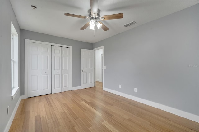 unfurnished bedroom with ceiling fan, a closet, and light hardwood / wood-style flooring