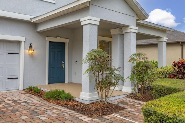 view of exterior entry featuring covered porch