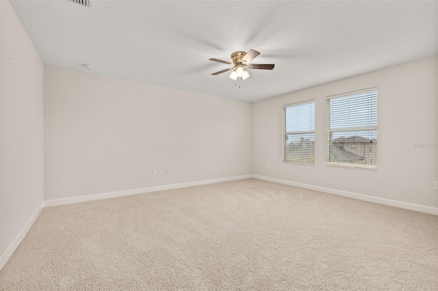 carpeted spare room featuring ceiling fan and a textured ceiling