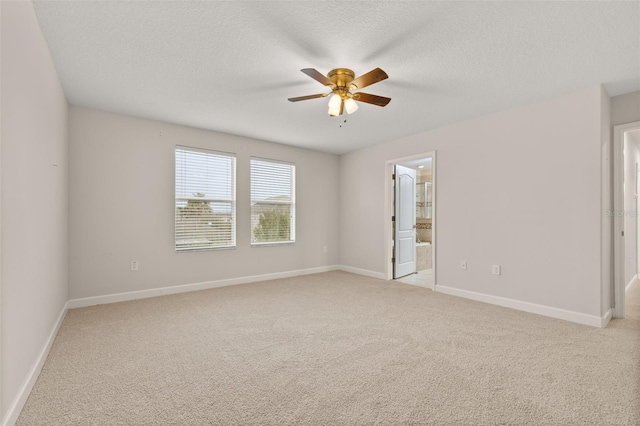 carpeted empty room with ceiling fan and a textured ceiling