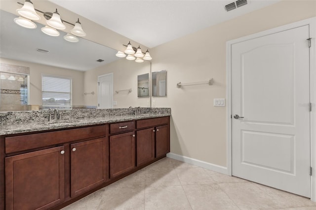 bathroom with tile patterned flooring, vanity, and a shower with shower door