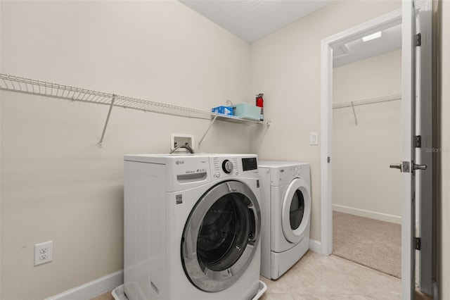 washroom with light tile patterned floors and washing machine and clothes dryer