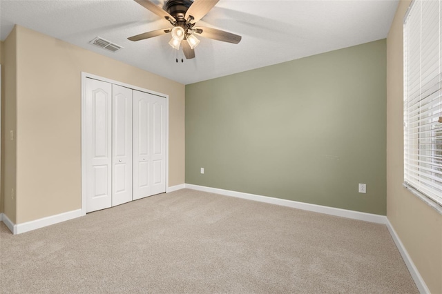 unfurnished bedroom featuring ceiling fan, carpet floors, and a closet