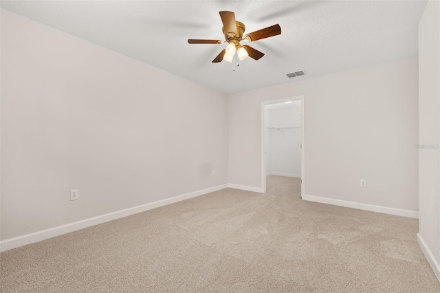 unfurnished room with ceiling fan and light carpet