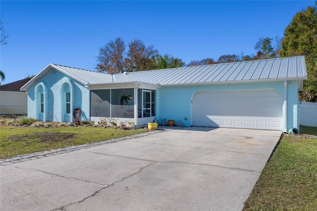 ranch-style house with a front yard, a garage, and a sunroom