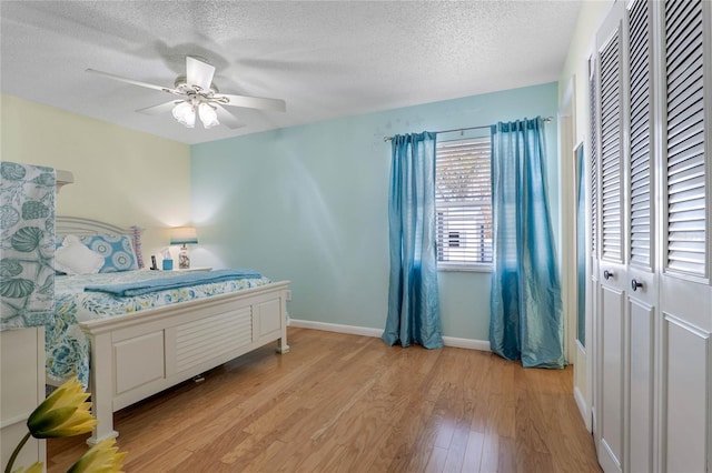 bedroom featuring ceiling fan, a textured ceiling, and light wood-type flooring