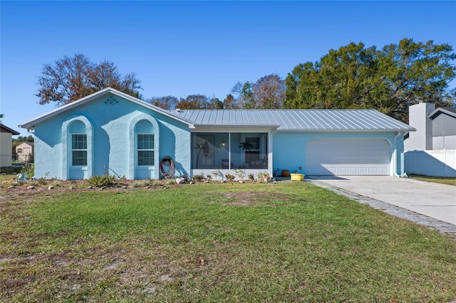 ranch-style house with a sunroom, a front yard, and a garage