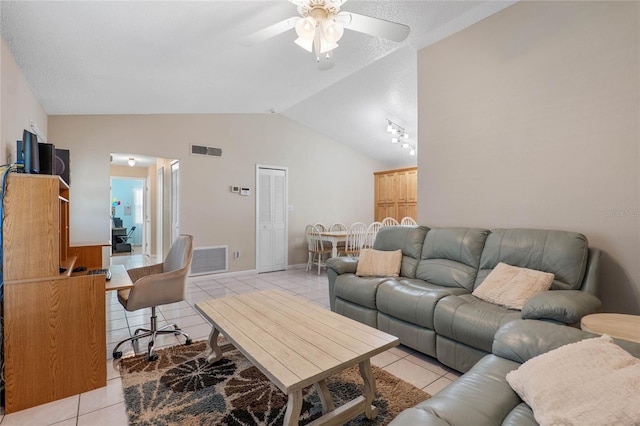 living room with lofted ceiling, ceiling fan, and light tile patterned floors