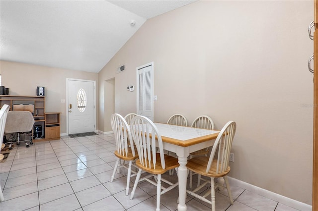 tiled dining space with lofted ceiling