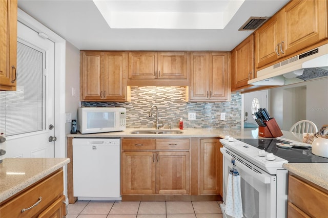 kitchen featuring decorative backsplash, light stone counters, white appliances, sink, and light tile patterned floors