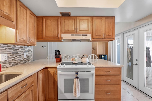 kitchen featuring backsplash, white electric range, light tile patterned floors, light stone counters, and kitchen peninsula