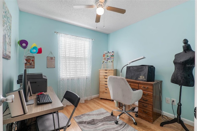 office area with ceiling fan, light hardwood / wood-style floors, and a textured ceiling