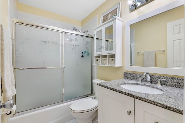 full bathroom with vanity, toilet, and combined bath / shower with glass door