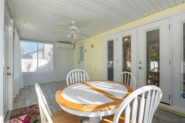 sunroom featuring a wall mounted AC, ceiling fan, and french doors