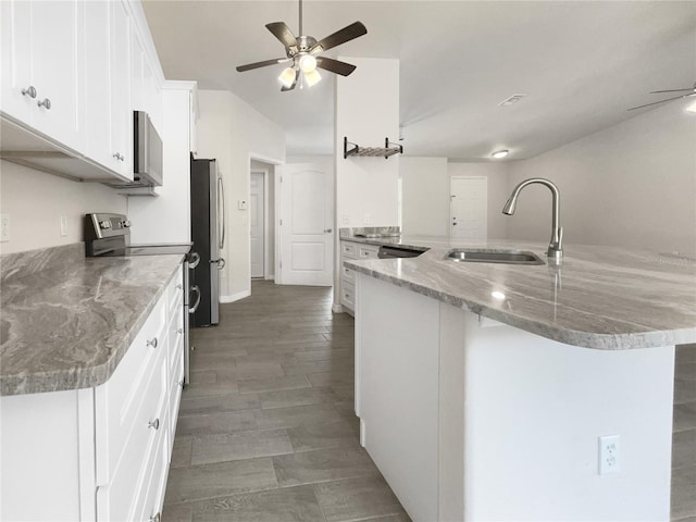 kitchen featuring sink, kitchen peninsula, a breakfast bar area, white cabinets, and appliances with stainless steel finishes