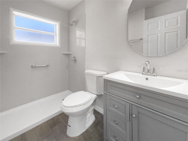 bathroom featuring hardwood / wood-style flooring, vanity, toilet, and walk in shower