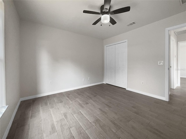 unfurnished bedroom with a closet, ceiling fan, and dark wood-type flooring