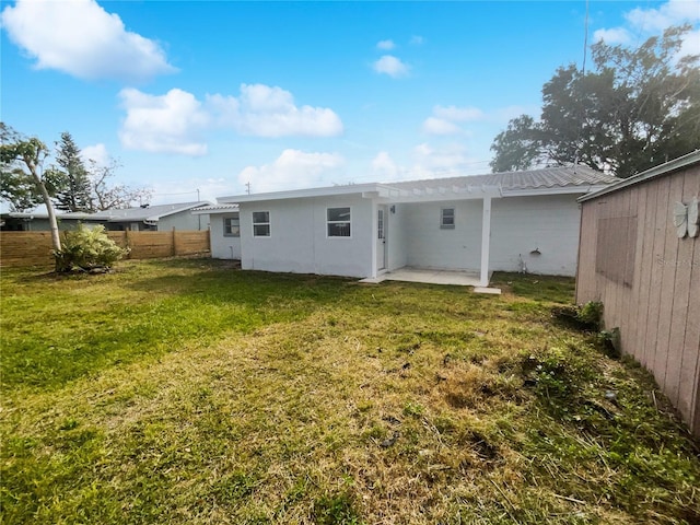 rear view of house featuring a yard