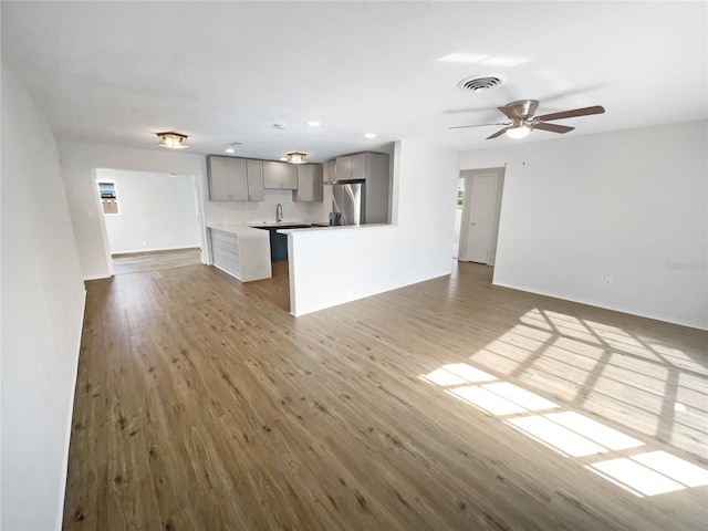 unfurnished living room featuring hardwood / wood-style floors and ceiling fan