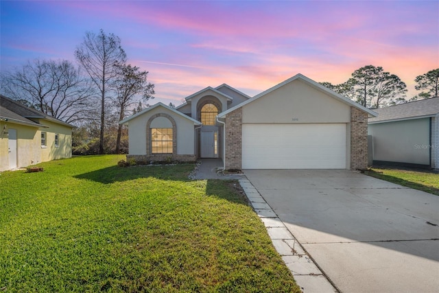 ranch-style home with a yard and a garage