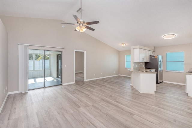 kitchen with light hardwood / wood-style flooring, ceiling fan, light stone countertops, white cabinetry, and stainless steel fridge with ice dispenser