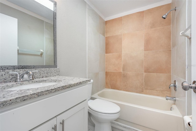 full bathroom featuring tiled shower / bath combo, toilet, and vanity