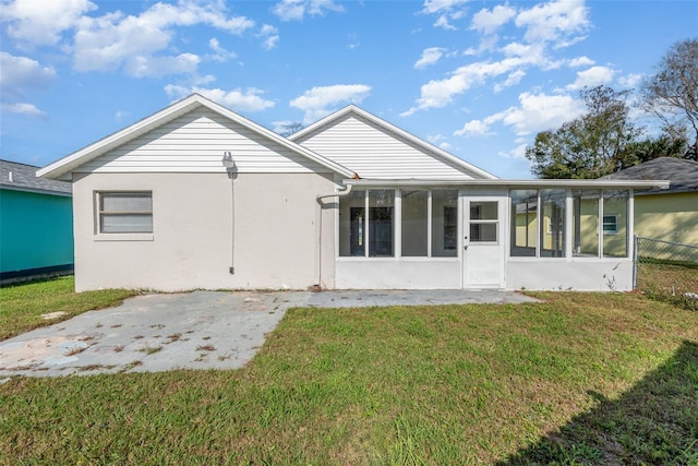 back of house with a lawn, a patio area, and a sunroom