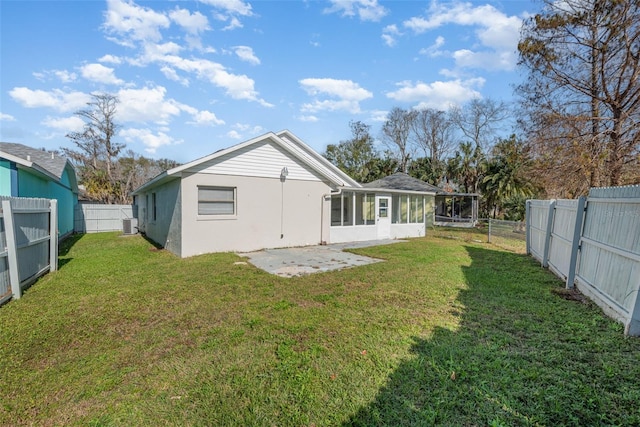 rear view of property with a sunroom, a yard, and a patio