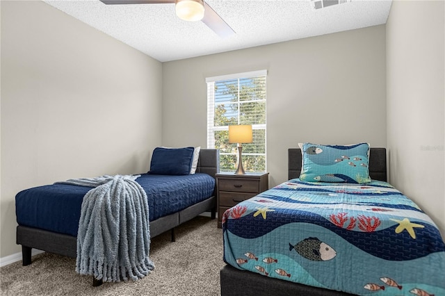 bedroom with a textured ceiling, ceiling fan, and light carpet