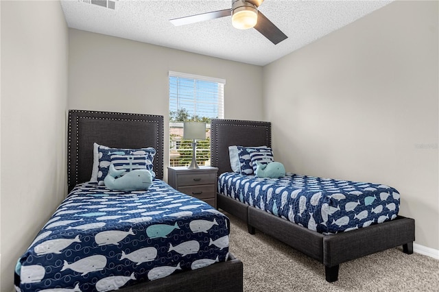 carpeted bedroom with ceiling fan and a textured ceiling