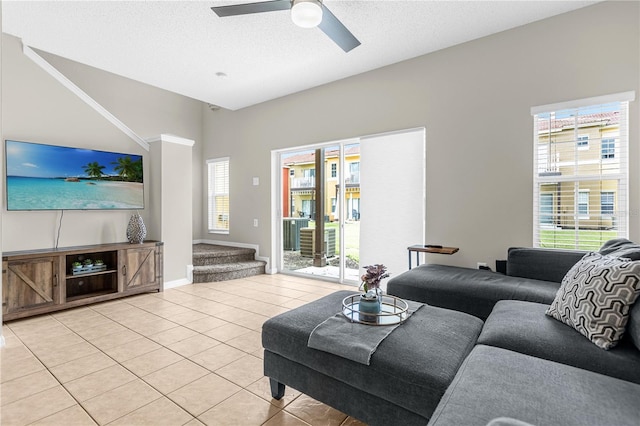 tiled living room featuring ceiling fan, a healthy amount of sunlight, and a textured ceiling