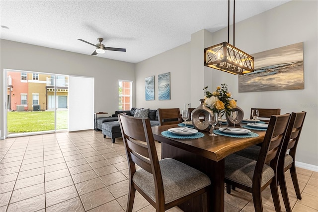 tiled dining area with ceiling fan and a textured ceiling